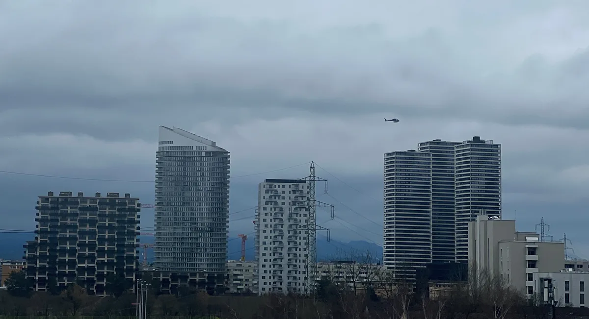 Hochhäuser und ein fliegender Helikopter.